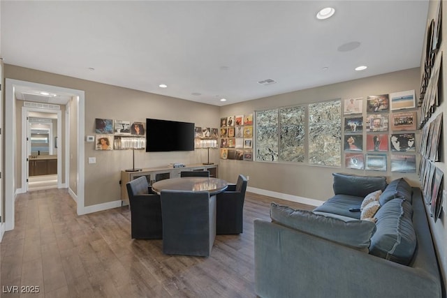 living room with baseboards, visible vents, wood finished floors, and recessed lighting