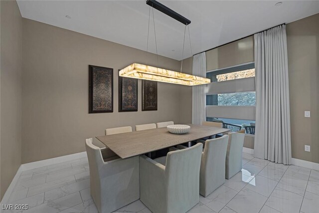 dining space with marble finish floor and baseboards