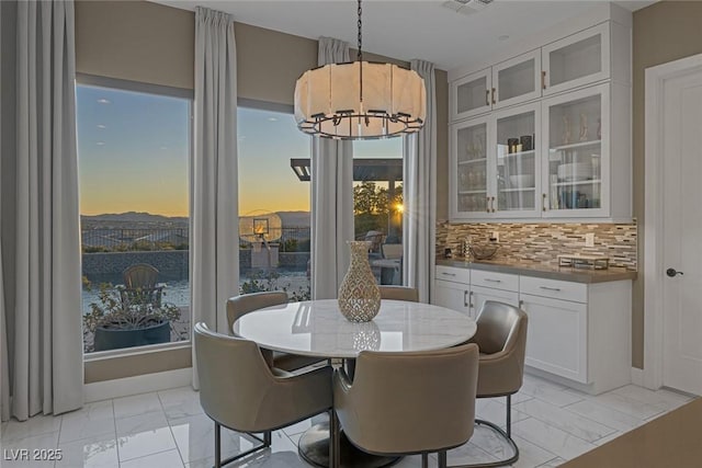 dining room featuring baseboards, marble finish floor, visible vents, and a notable chandelier