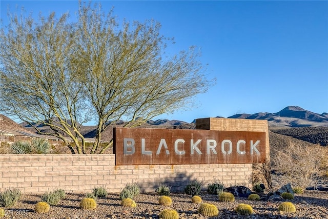 community / neighborhood sign with a mountain view