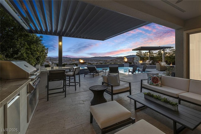 patio terrace at dusk featuring an outdoor living space, a fenced in pool, and area for grilling