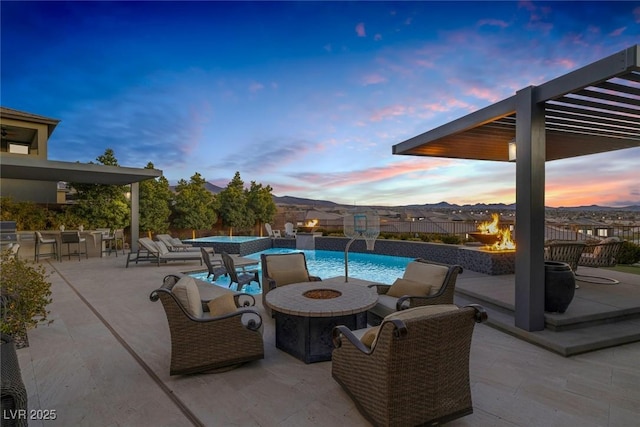 patio terrace at dusk with an outdoor pool, an outdoor fire pit, and outdoor dry bar