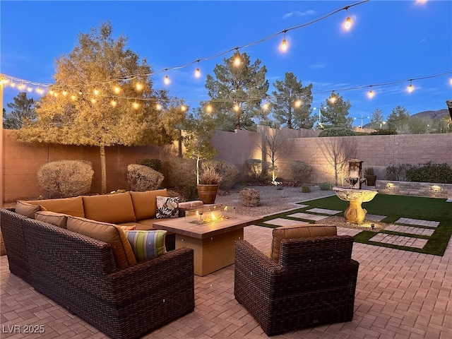 patio terrace at dusk featuring an outdoor living space with a fire pit