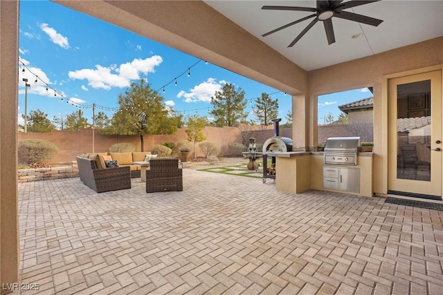 view of patio / terrace featuring ceiling fan, a fenced backyard, outdoor lounge area, exterior kitchen, and grilling area