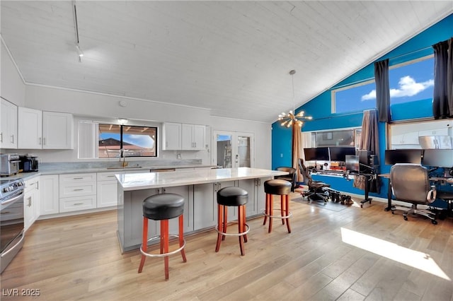 kitchen with hanging light fixtures, a kitchen bar, white cabinets, and a center island