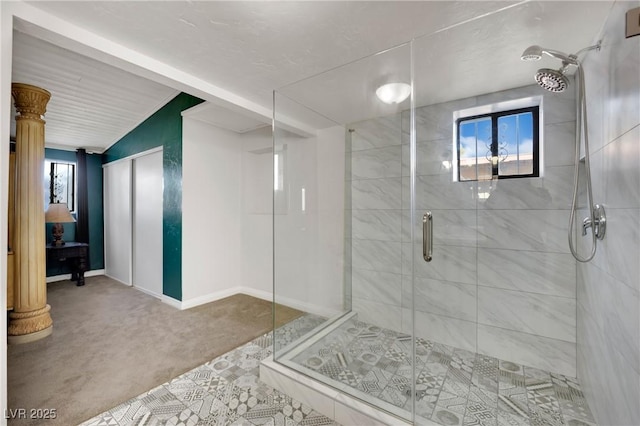 full bath featuring a stall shower, decorative columns, lofted ceiling, and baseboards