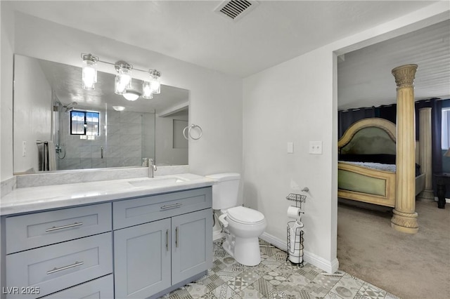 ensuite bathroom with a stall shower, baseboards, visible vents, connected bathroom, and vanity