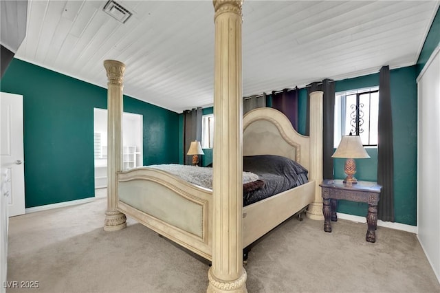 carpeted bedroom with visible vents, decorative columns, and baseboards