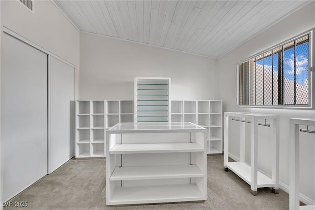 walk in closet featuring lofted ceiling, light carpet, and visible vents