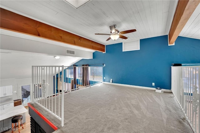 interior space featuring visible vents, vaulted ceiling with beams, baseboards, and ceiling fan