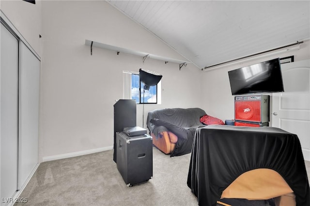 carpeted bedroom with vaulted ceiling, a closet, and baseboards