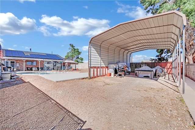 view of vehicle parking featuring a carport, fence, and driveway