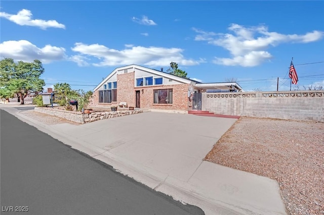 view of front of home with brick siding and fence