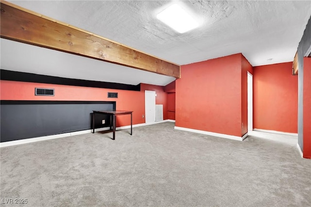 interior space with carpet, visible vents, a textured ceiling, and baseboards