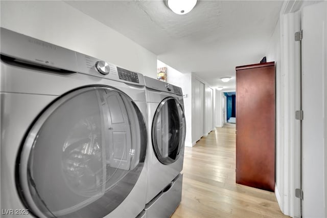 laundry room featuring washer and dryer, laundry area, a textured ceiling, and light wood finished floors