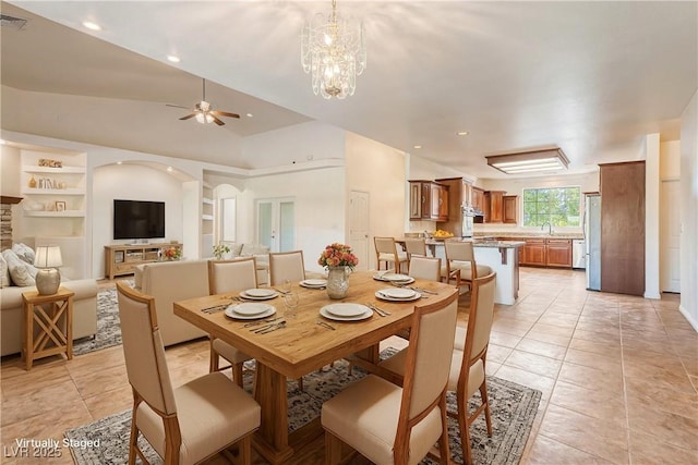 tiled dining area featuring sink, ceiling fan with notable chandelier, vaulted ceiling, and built in features