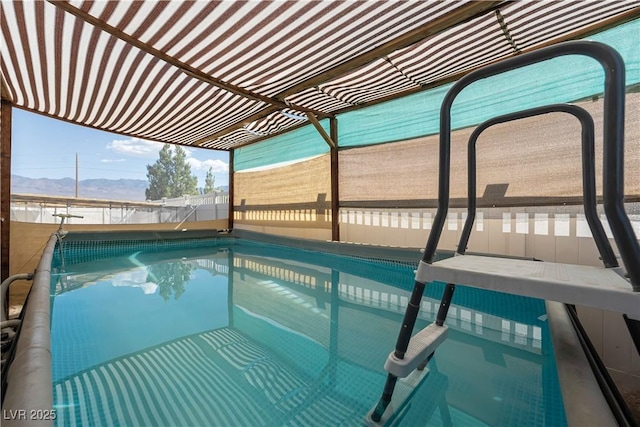 view of swimming pool with a mountain view and a pergola