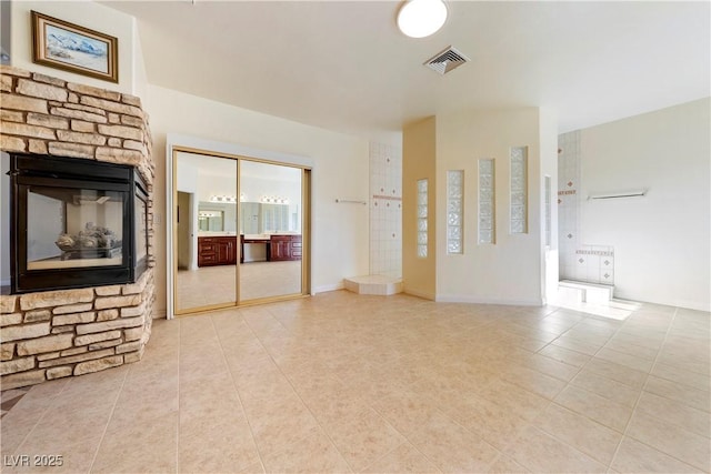 unfurnished living room featuring a fireplace and light tile patterned floors