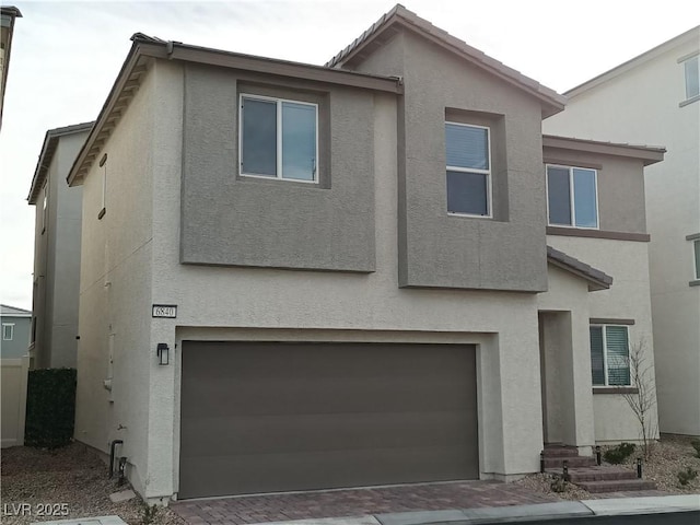 view of front of home featuring an attached garage, entry steps, a tiled roof, and stucco siding