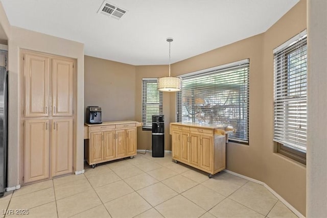 kitchen with pendant lighting, light brown cabinetry, and light tile patterned floors