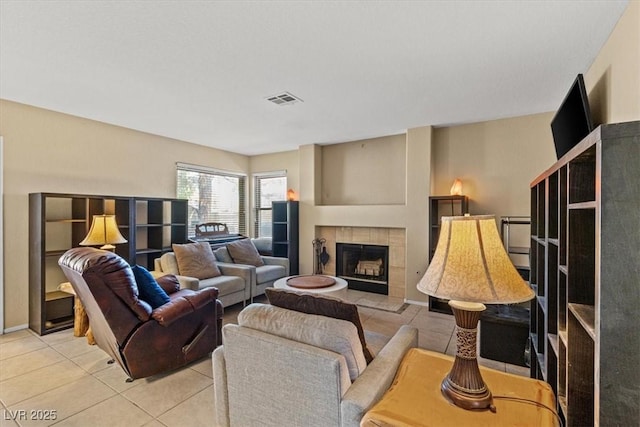 living room with a tiled fireplace and light tile patterned floors