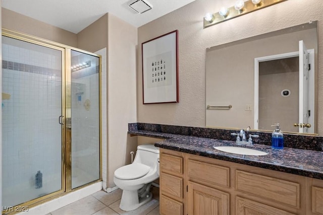 bathroom with vanity, walk in shower, tile patterned floors, and toilet