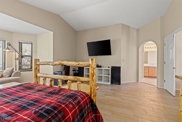 bedroom with lofted ceiling, ensuite bathroom, and hardwood / wood-style floors