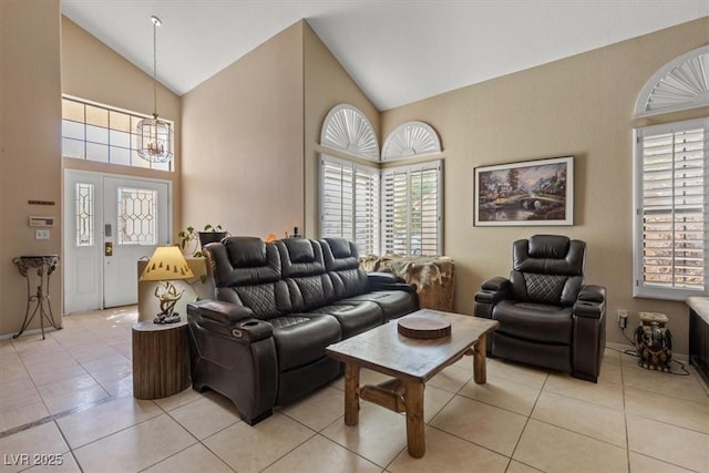 living room featuring an inviting chandelier, light tile patterned floors, and high vaulted ceiling