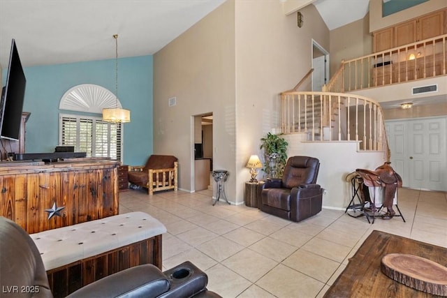 living room with light tile patterned flooring, an inviting chandelier, and high vaulted ceiling