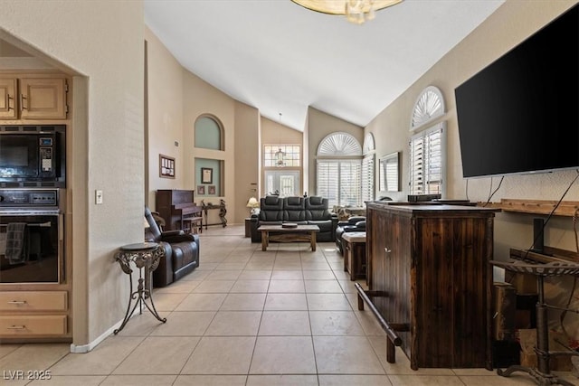 living room featuring light tile patterned flooring and high vaulted ceiling