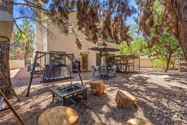 view of patio / terrace featuring a jacuzzi and an outdoor fire pit