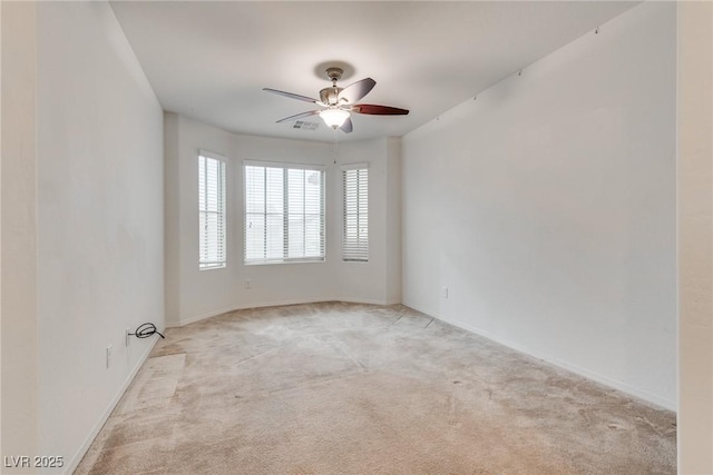 empty room with baseboards, light colored carpet, and a ceiling fan