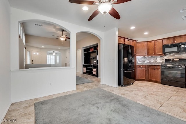 kitchen featuring visible vents, arched walkways, ceiling fan, black appliances, and brown cabinets