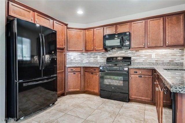 kitchen with decorative backsplash, black appliances, brown cabinetry, and light stone countertops