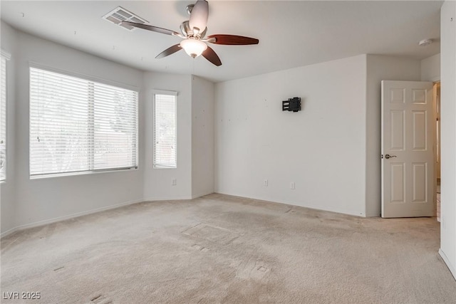 spare room with visible vents, light colored carpet, and a ceiling fan