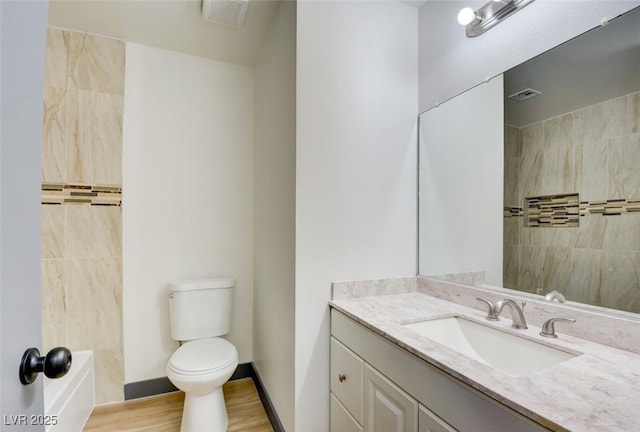 full bathroom featuring tiled shower / bath combo, vanity, wood-type flooring, and toilet