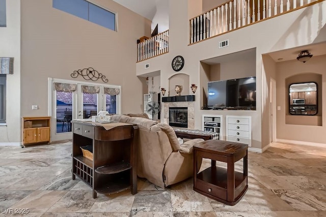 living room with a fireplace and a high ceiling