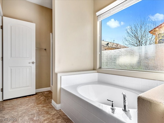 full bathroom featuring a garden tub, baseboards, and tile patterned floors