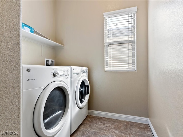 clothes washing area featuring laundry area, plenty of natural light, baseboards, and washer and clothes dryer