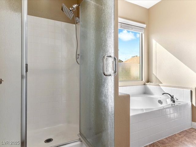 bathroom with a stall shower and a garden tub