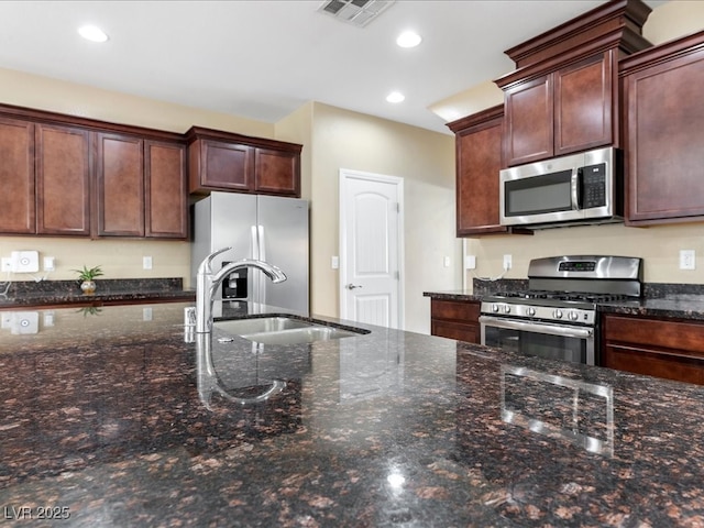 kitchen with appliances with stainless steel finishes, a sink, visible vents, and recessed lighting