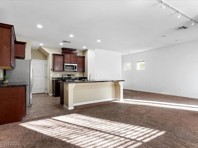 kitchen with stainless steel appliances, carpet floors, a sink, and visible vents