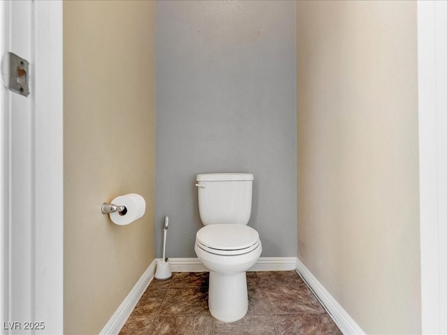 bathroom with tile patterned flooring, toilet, and baseboards