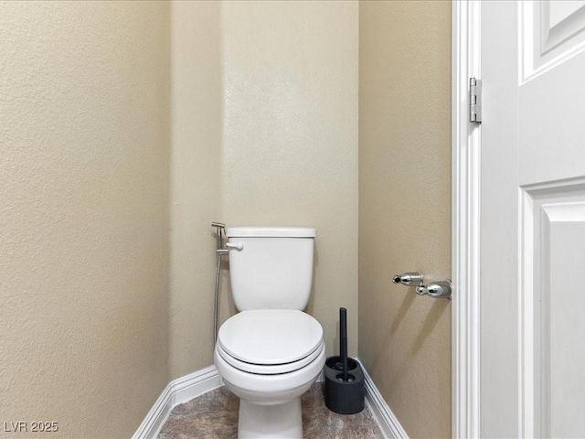 bathroom featuring toilet and baseboards