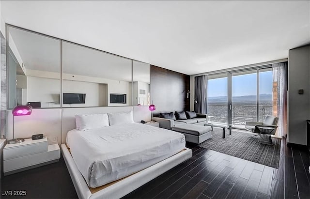 4381 W Flamingo Rd Unit 3007, Las Vegas, NV 89103 - bedroom featuring a wall of windows and dark wood finished floors