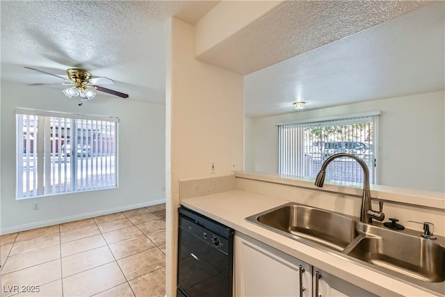 kitchen with white cabinetry, black dishwasher, sink, light tile patterned floors, and a textured ceiling