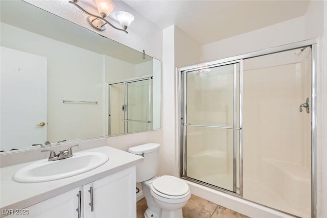 bathroom with tile patterned floors, vanity, toilet, and a shower with shower door