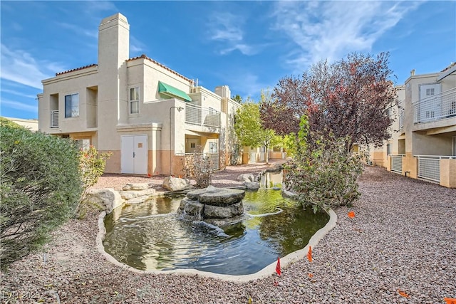 view of property's community with a garden pond