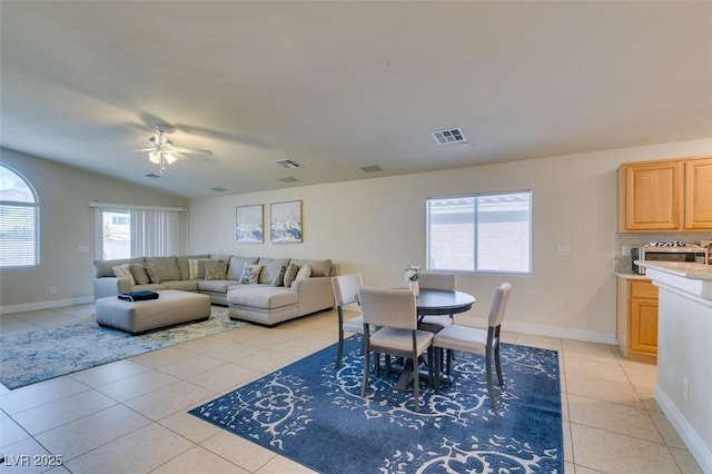 living room with lofted ceiling, light tile patterned floors, and ceiling fan