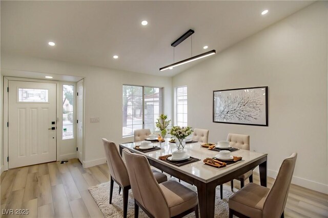 dining area with lofted ceiling, light wood-style flooring, recessed lighting, and baseboards